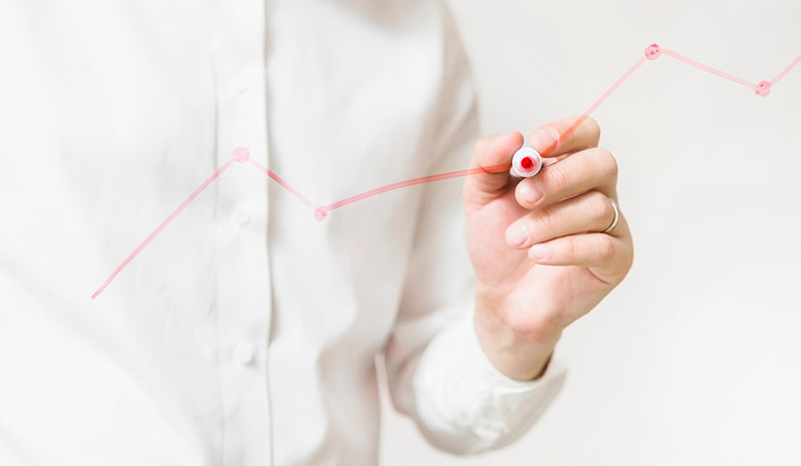 Person drawing a line chart with a marker pen