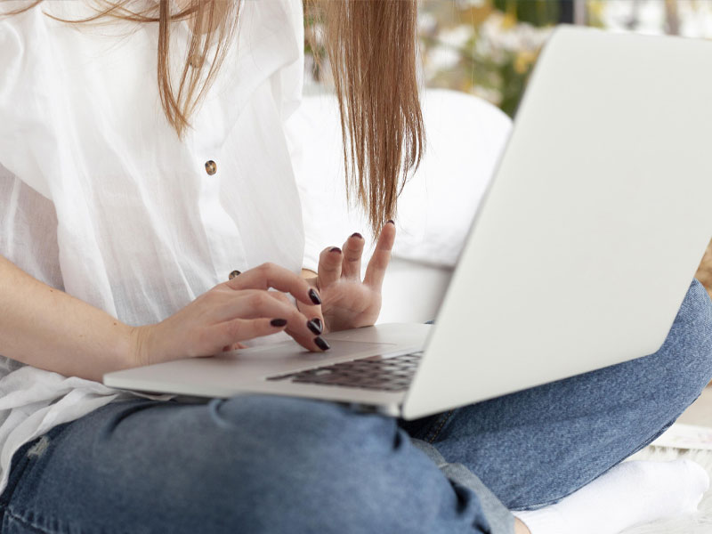 Woman working with her laptop her lap