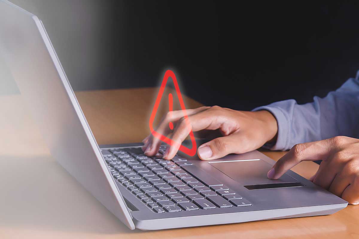 Person typing in a laptop with a red arrow screen abstract graphic