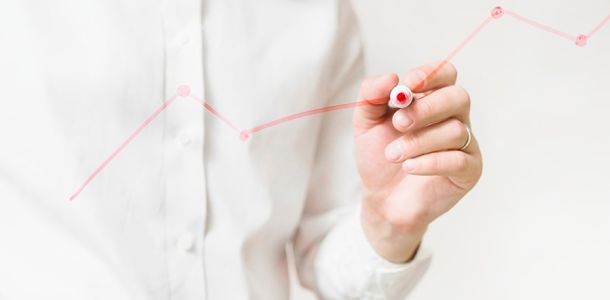 Person drawing a line chart with a marker pen