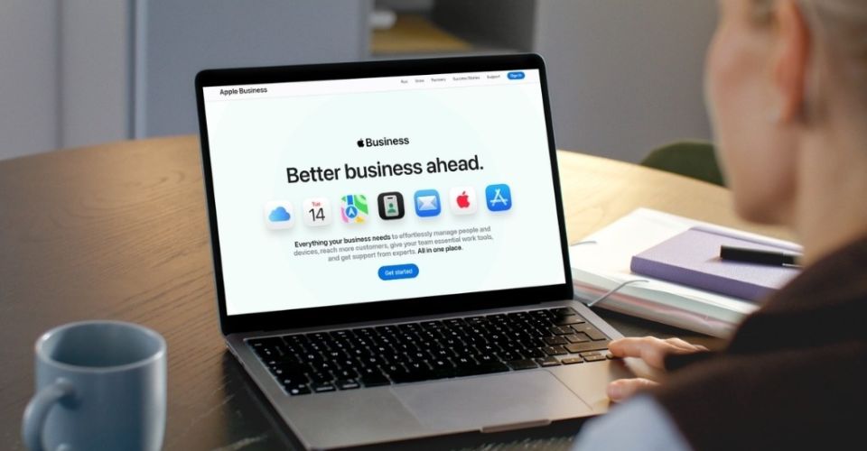 Person viewing the Apple Business website on a laptop at a desk.