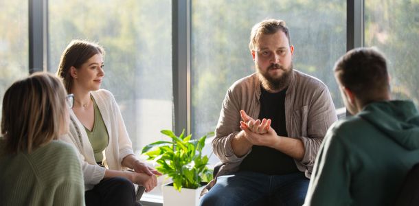 A group of people engaged in conversation while seated in a room.