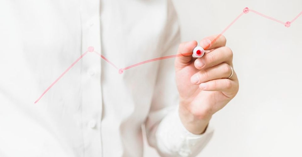 Person drawing a line chart with a marker pen